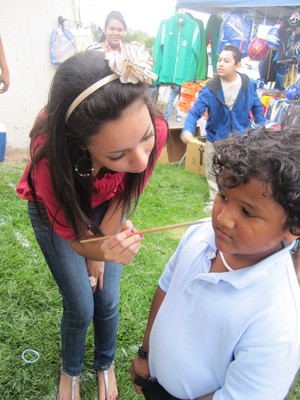 A young boy getting his face painted